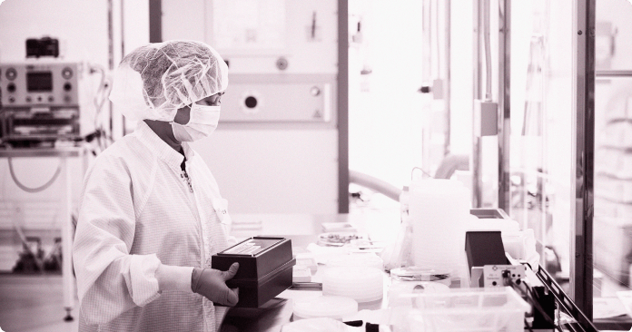 4 team members in lap coats having a discussion in a lab