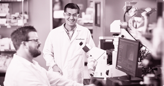 Two team members working near microscopes